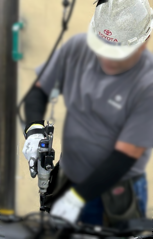 Assembly-line worker wearing ARTUS while operating a power tool